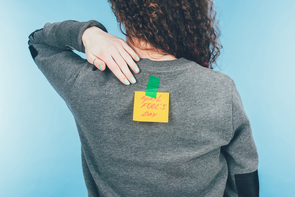 vista posterior de la mujer con nota en cinta adhesiva con letras de día tontos abril en la espalda, concepto de día tontos abril
 - Foto, Imagen