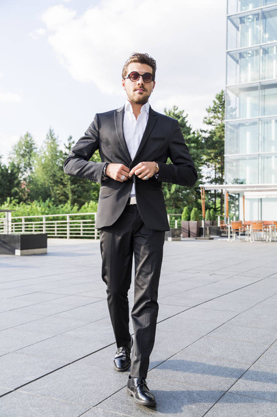 Male businessman or worker in black suit walk on the street - Zdjęcie, obraz