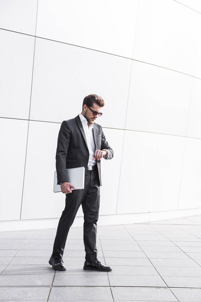 Male businessman or worker in black suit with laptop - Fotografie, Obrázek