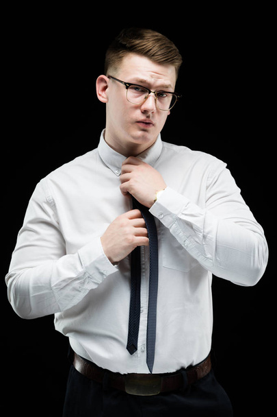 Blonde man stropdas vaststelling tijdens het kijken naar camera - Foto, afbeelding