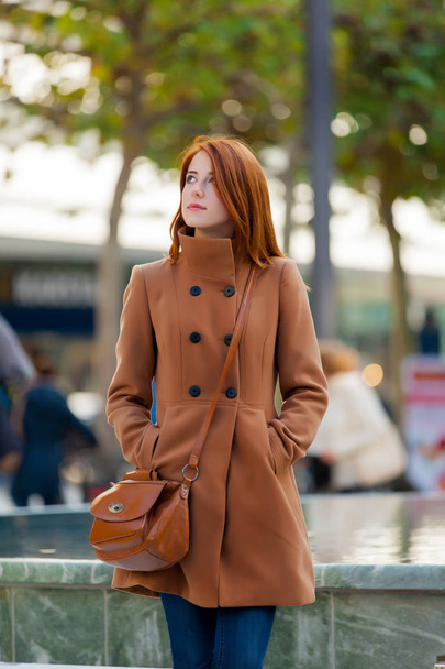 Young redhead woman in coat have a rest on Frankfurt streets, Germany  - Fotografie, Obrázek