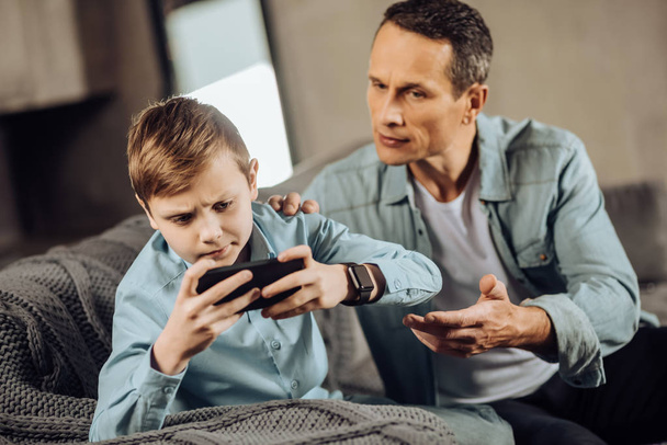 Strict father trying to make son stop playing - Photo, Image