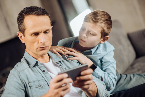 Upset boy searching attention from his father - Foto, Bild