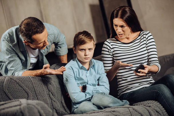 Young parents explaining son about drawbacks of binge-playing - Fotoğraf, Görsel