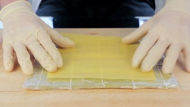 Šéfkuchař připravuje sushi umístěním rýže na řasy Nuri - Záběry, video