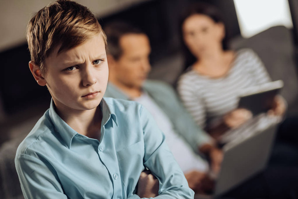 Upset pre-teen boy lacking his parents attention - Photo, image