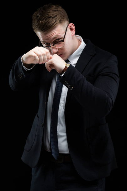 Blonde man strijd gebaar toont op zwarte achtergrond - Foto, afbeelding