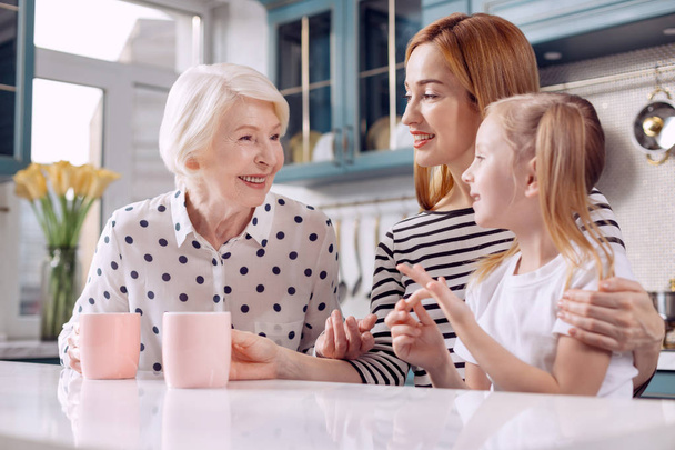 Pleasant elderly woman sharing experience with granddaughter - Valokuva, kuva