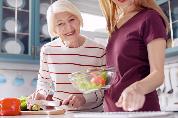 Cheerful women consulting tablet for salad recipe - Foto, Bild