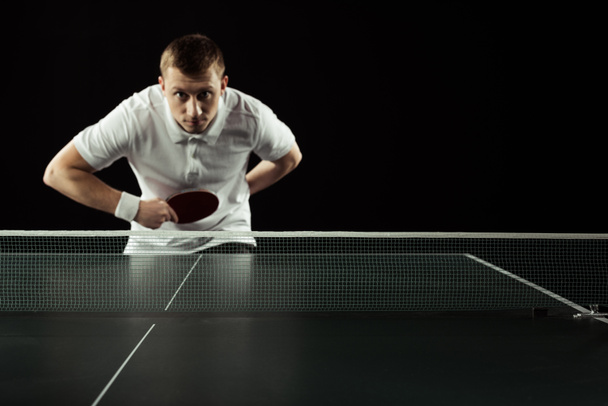selective focus of young tennis player playing table tennis isolated on black - Foto, immagini