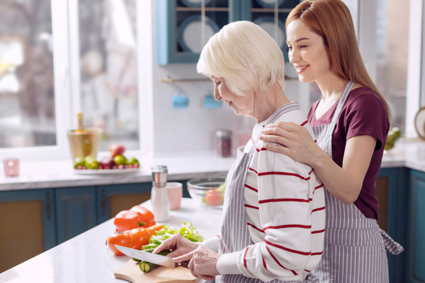 Веселі жінки зв'язуються з мамою під час приготування їжі
 - Фото, зображення