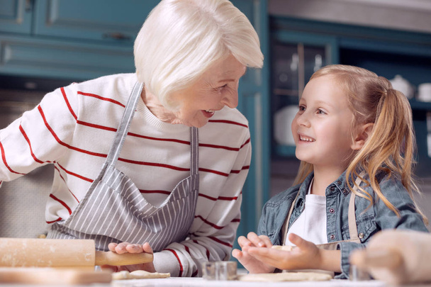 Grandmother and granddaughter discussing cookie-making - Fotó, kép