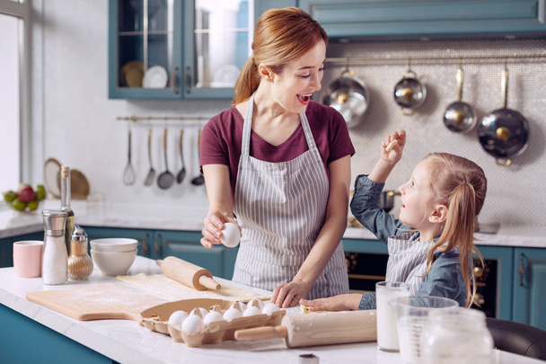 Little girl and helping her mother bake cookies - Foto, Imagen