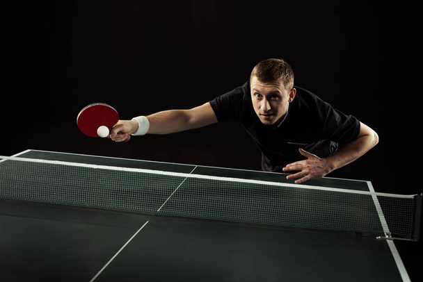 tennista in uniforme giocare a ping pong isolato su nero
 - Foto, immagini