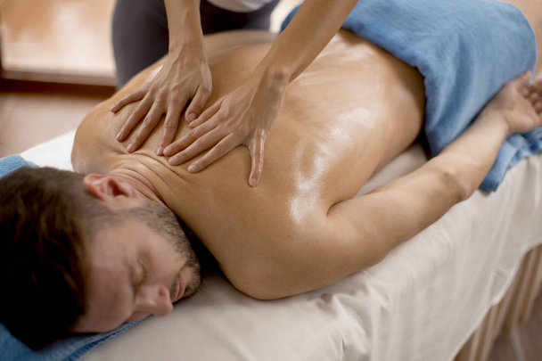 Hombre joven que tiene masaje relajante en el spa
 - Foto, imagen