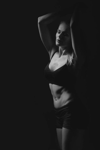 sport blonde woman on black background - Foto, afbeelding