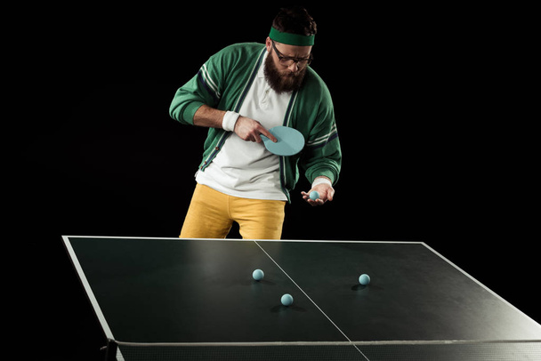 bearded tennis player practicing in table tennis isolated on black - Foto, Imagen
