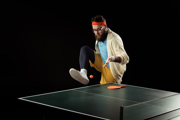jogador de tênis barbudo jogando com bola perto de bola de tênis isolado em preto
 - Foto, Imagem