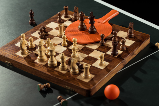 close up view of tennis racket, ball and chess board with figures on tennis table - Photo, Image