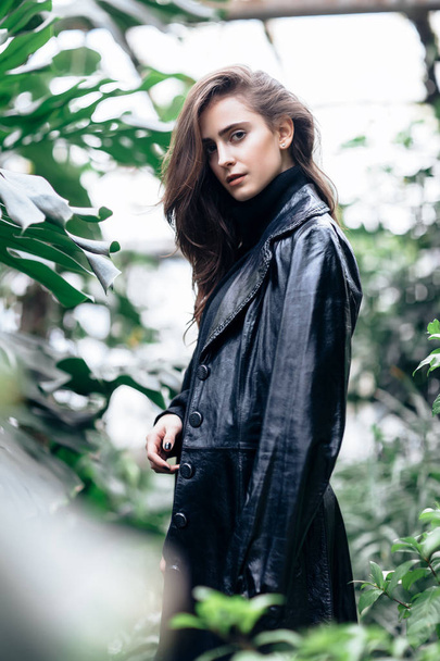 Fashion portrait of beautiful stylish woman in leather jacket on nature background - 写真・画像