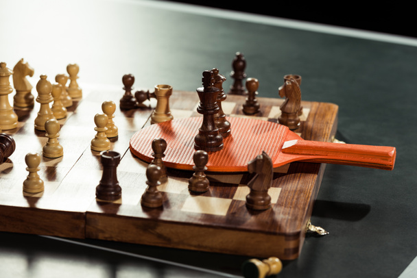 close up view of tennis racket and chess board with figures on tennis table - Photo, Image