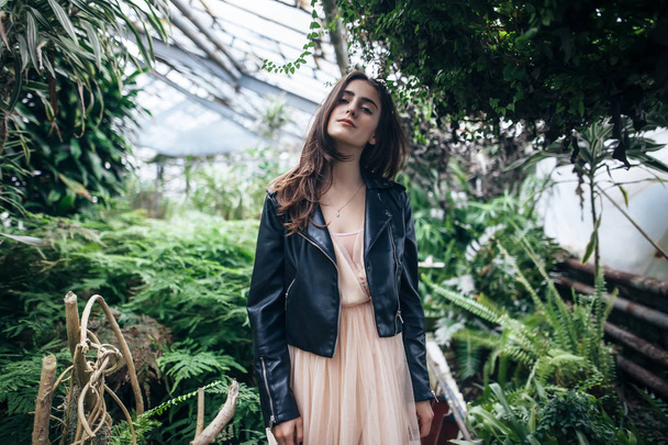Beautiful dreaming woman with closed eyes posing in garden greenhouse background. Fashion concept - Photo, Image