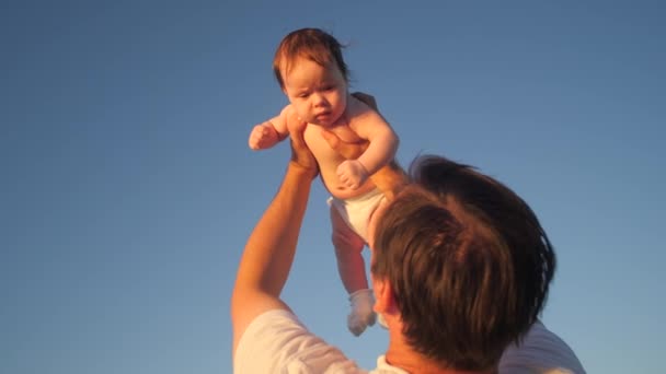 Isä heittää vauvan siniselle taivaalle. Hidastus
. - Materiaali, video