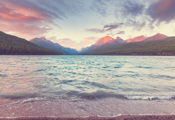 Озеро Бауман прекрасно віддзеркалює захопливі гори в Глейшерському національному парку (штат Монтана, США). Фільтр Instagram. - Фото, зображення