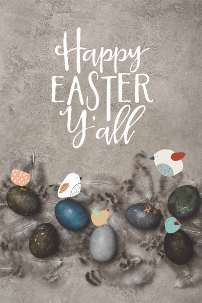 top view of painted easter eggs with feathers on concrete surface with birds and Happy Easter you all lettering - Fotografie, Obrázek