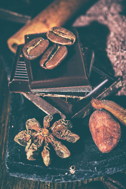 Broken dark chocolate, cocoa powder and coffee beans on a wooden table - Foto, Imagen