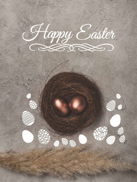 top view of golden easter eggs in nest on concrete surface with Happy Easter lettering - Foto, Imagen