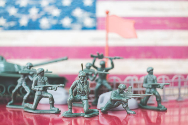 Miniatuur speelgoed soldaten in de slag bij scène met Amerikaanse vlag achtergrond - Foto, afbeelding