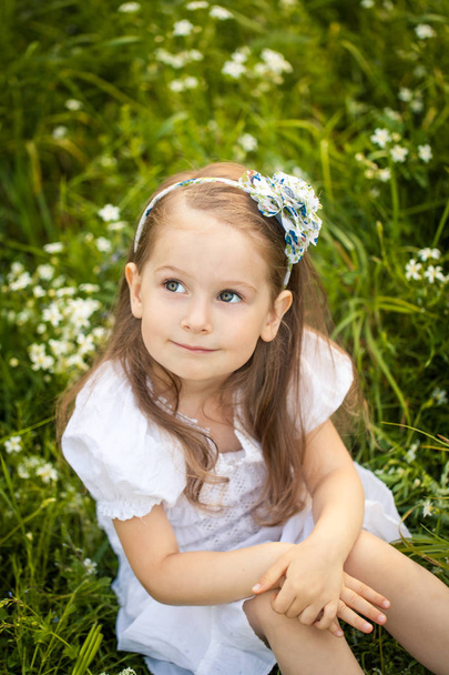 Little girl in a field with white flowers - Фото, зображення