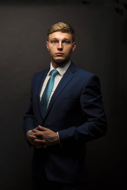 Businessman in suit over dark background portrait. - Foto, Imagen