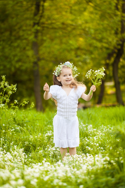 kleines Mädchen in einem Feld mit weißen Blumen - Foto, Bild