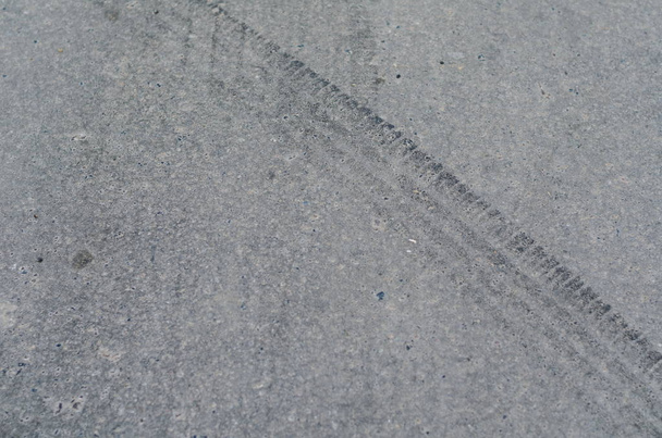 Traces of wheel tires on gray asphalt road  - Photo, Image