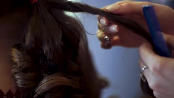 blonde stylist girl makes hairstyle to a young woman - Filmati, video