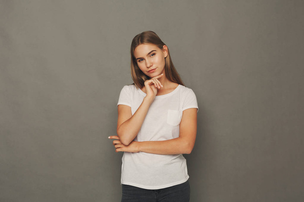 Pensive young woman on gray studio background - Photo, Image