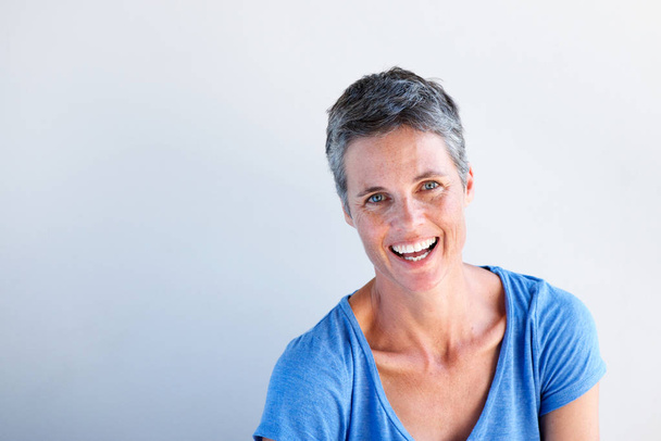 Close up portrait of happy mature woman laughing against white background - Photo, Image