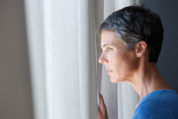 Πορτραίτο γυναίκας μεγαλύτερης ηλικίας, κοιτάζοντας από το παράθυρο - Φωτογραφία, εικόνα