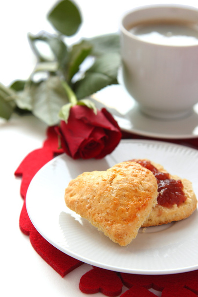 καρδιά σχήμα scones με μαρμελάδα φράουλα και ένα φλιτζάνι τσάι - Φωτογραφία, εικόνα