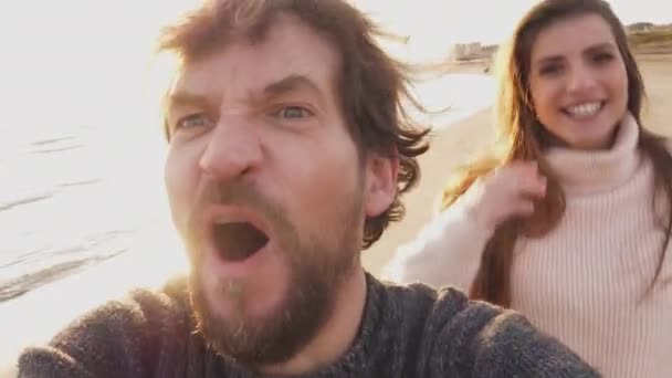 Feliz pareja haciendo divertido selfie vídeo corriendo en la playa
 - Imágenes, Vídeo