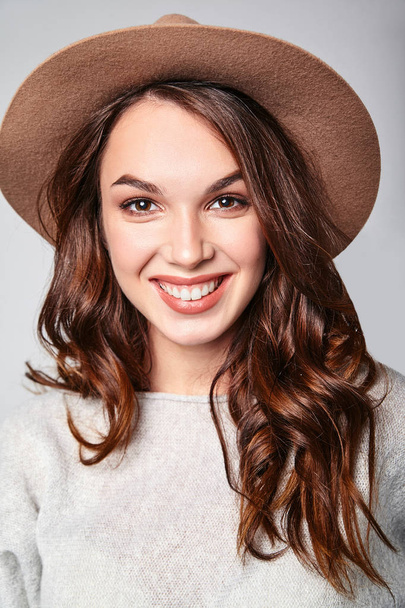 Portrait of young stylish laughing girl model in gray casual summer clothes in brown hat with natural makeup isolated on gray background. Looking at camera - Foto, Imagem