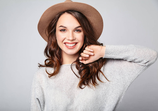 Portrait of young stylish laughing girl model in gray casual summer clothes in brown hat with natural makeup isolated on gray background. Looking at camera - Foto, Imagem