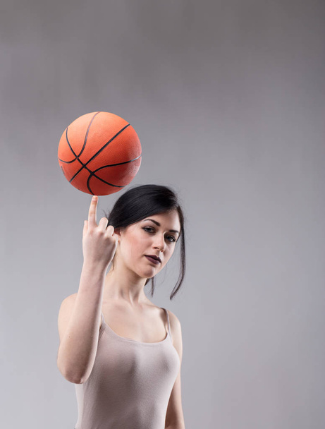 attraktive sportliche Frau balanciert einen Basketball - Foto, Bild