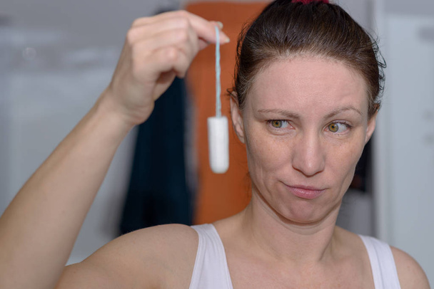 Frau hält Tampon für starken Blutfluss hoch - Foto, Bild