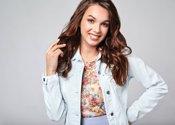 Portrét mladé stylové smějící se dívka modelu v barevné ležérní letní oblečení s přírodní make-up izolovaných na šedém pozadí. Při pohledu na fotoaparát - Fotografie, Obrázek