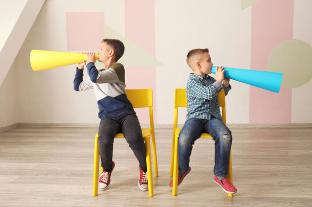 Funny little boys with paper megaphones indoors - Foto, imagen