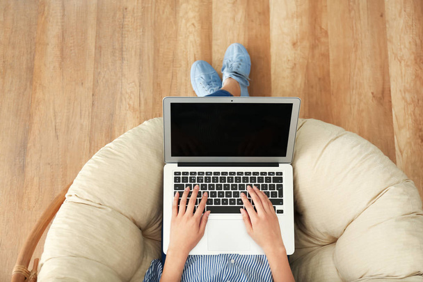 Young woman using laptop indoors - Φωτογραφία, εικόνα
