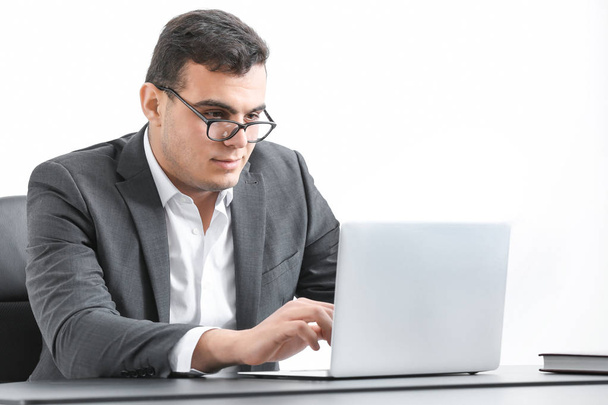 Young man in office wear working with laptop at table - Foto, afbeelding